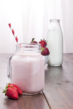 Strawberry milkshake, strawberries and milk bottle.