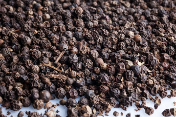 Black pepper scattered on white background