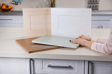 Female hands holding samples of wooden panels for furniture and door