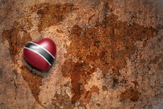 heart with national flag of trinidad and tobago on a vintage world map crack paper background. concept