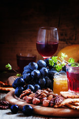 Rose wine and wooden dish with various snacks, vintage backgroun