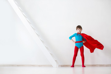 Fototapeta na wymiar Leader. The boy super hero in a red cloak.