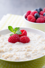 Oatmeal porridge in bowl with berries raspberries and blackberri