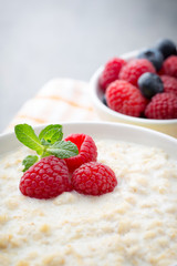 Oatmeal porridge in bowl with berries raspberries and blackberri