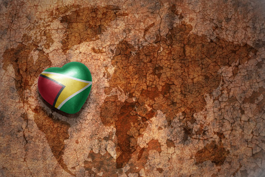 heart with national flag of guyana on a vintage world map crack paper background. concept