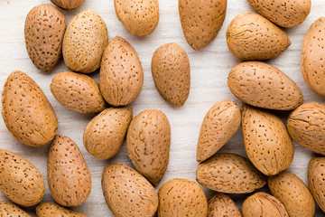 Group of almond nuts with leaves.Wooden background.
