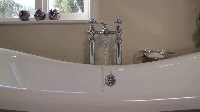Water flowing into a freestanding bath in slow motion.
