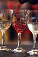 Red wine pouring into wine glass, closeup