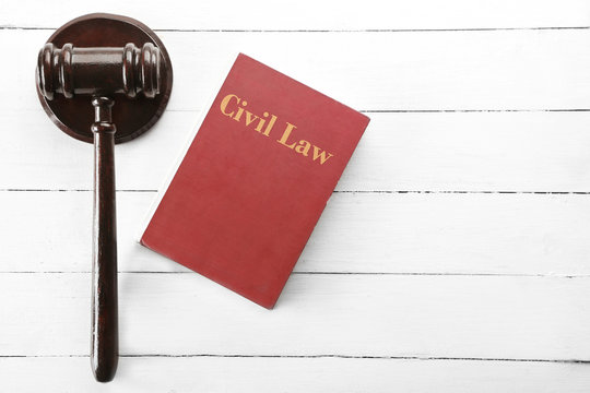 Gavel and book on wooden background