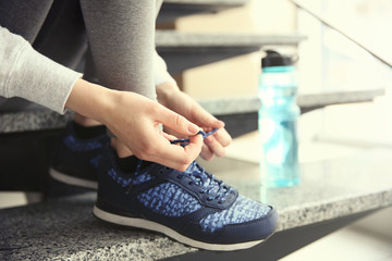 Woman tying up running shoe