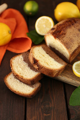 Delicious sweet cake bread with lemons on wooden table closeup