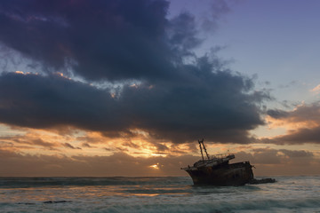 Old shipwreck long exposure on the rocks sunset