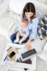 Beautiful woman with baby boy working from home using laptop, view from above