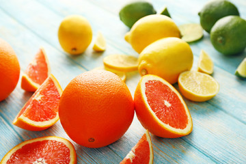 Juicy composition of citrus fruits on wooden background, close up