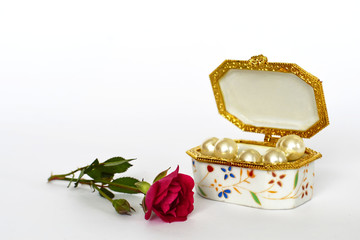 Jewelry box and rose on light background