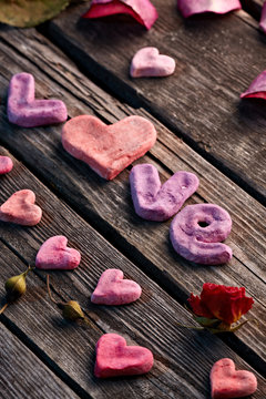 Word Love with rose petals and small heart