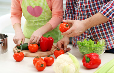 Happy couple cooking salad on the kitchen, close up