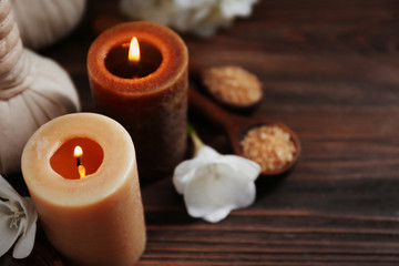 Fototapeta na wymiar Spa set with sea salt, exotic flowers and candles on wooden background