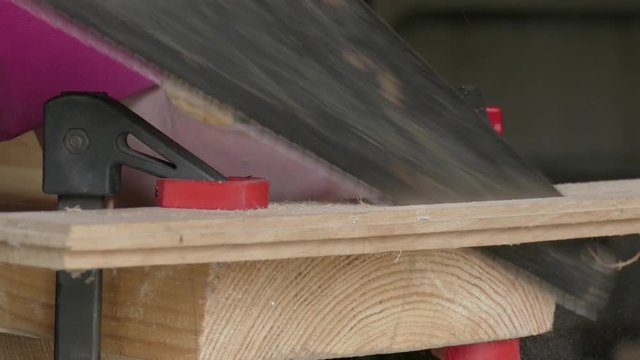 sawing of wooden plank using hacksaw
