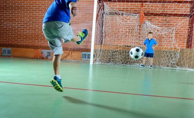 Young boy kicking a soccer ball for goal