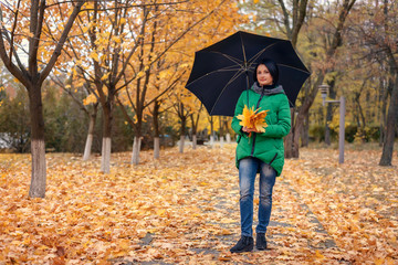 Single woman walking among fallen leaves