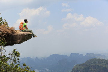 successful woman hiker enjoy the view on mountain top rock