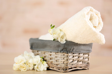 Obraz na płótnie Canvas Towel and flowers in wicker basket