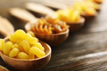 Various types of pasta in wooden spoons