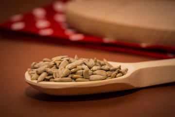 Sunflower seeds on a wooden spoon on the table