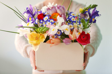 Woman holding a box of fresh flowers, close up