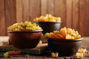 Different types of pasta on wooden background