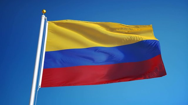 Colombia flag waving in slow motion against clean blue sky, seamlessly looped, close up, isolated on alpha channel with black and white luminance matte, perfect for film, news, digital composition