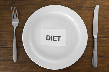 White plate with word diet on wooden background