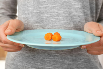 Woman holding a white plate with baby carrot slices
