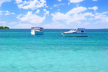 Fototapeta na wymiar Boats floating in blue ocean. Summer vacation concept.