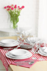 Table served with white dishes and a bouquet of tulips