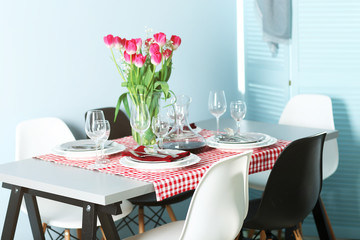 Table served with dishes and a bouquet of tulips