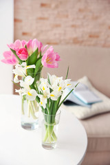 Beautiful fresh tulips and irises on table, indoors