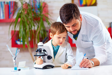 teacher helps kid to conduct experiment with microscope
