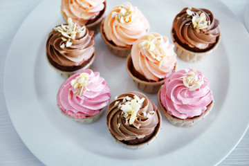 Creamy cupcakes on table closeup