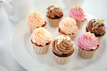 Creamy cupcakes on table closeup