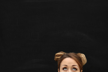 A forehead of a young blond girl  against blackboard.