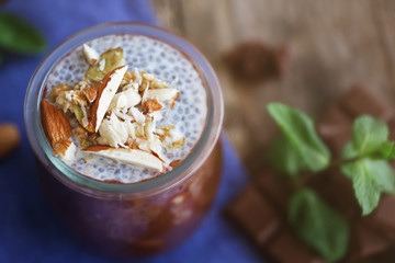 Chocolate chia seed pudding with crushed almonds on wooden table