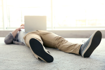 Young businessman working with a laptop on the floor