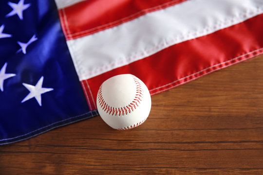 Baseball and American flag on wooden background. Popular sport concept