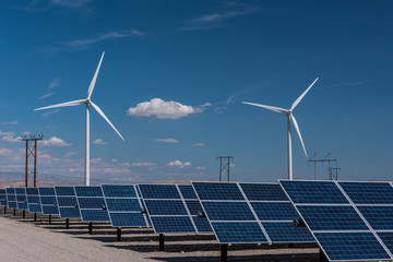 Solar panels and wind turbines in sunny desert