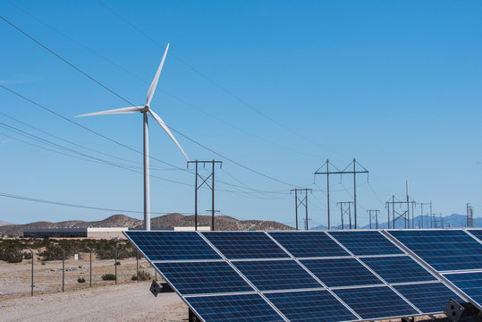 Solar panels and wind turbines in sunny desert