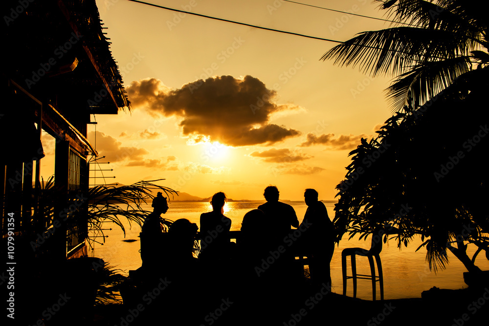 Wall mural silhouette of people at bar sunset background