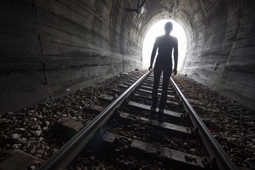 Man in a tunnel looking towards the light