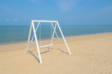 White swing on the sand beach.